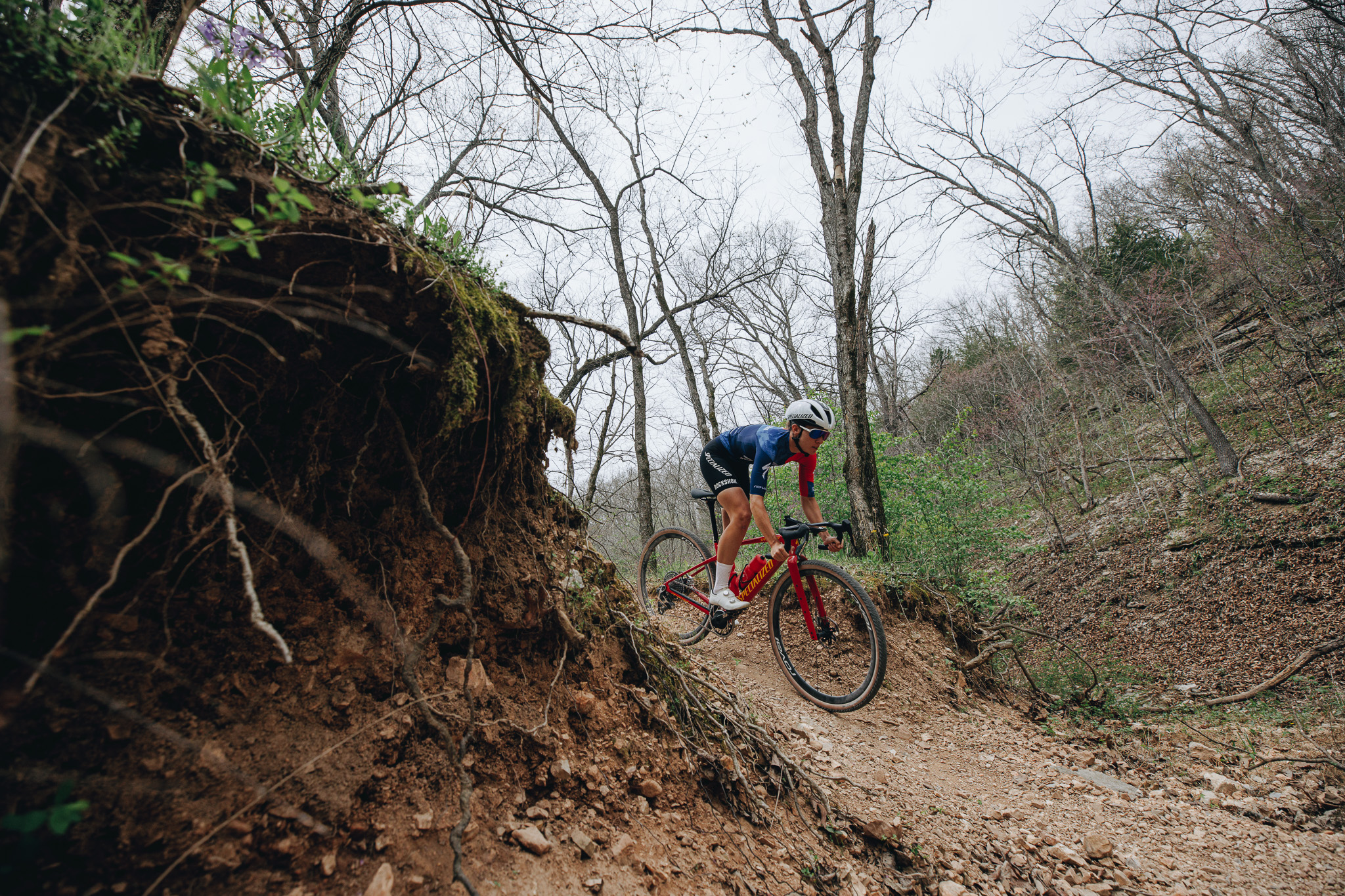 Gravelcyklist på en lövtäckt skogsstig bland avlövade träd – Specialized